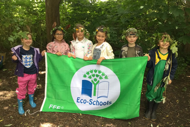 Children at Oasis Academy Putney show off their green flag